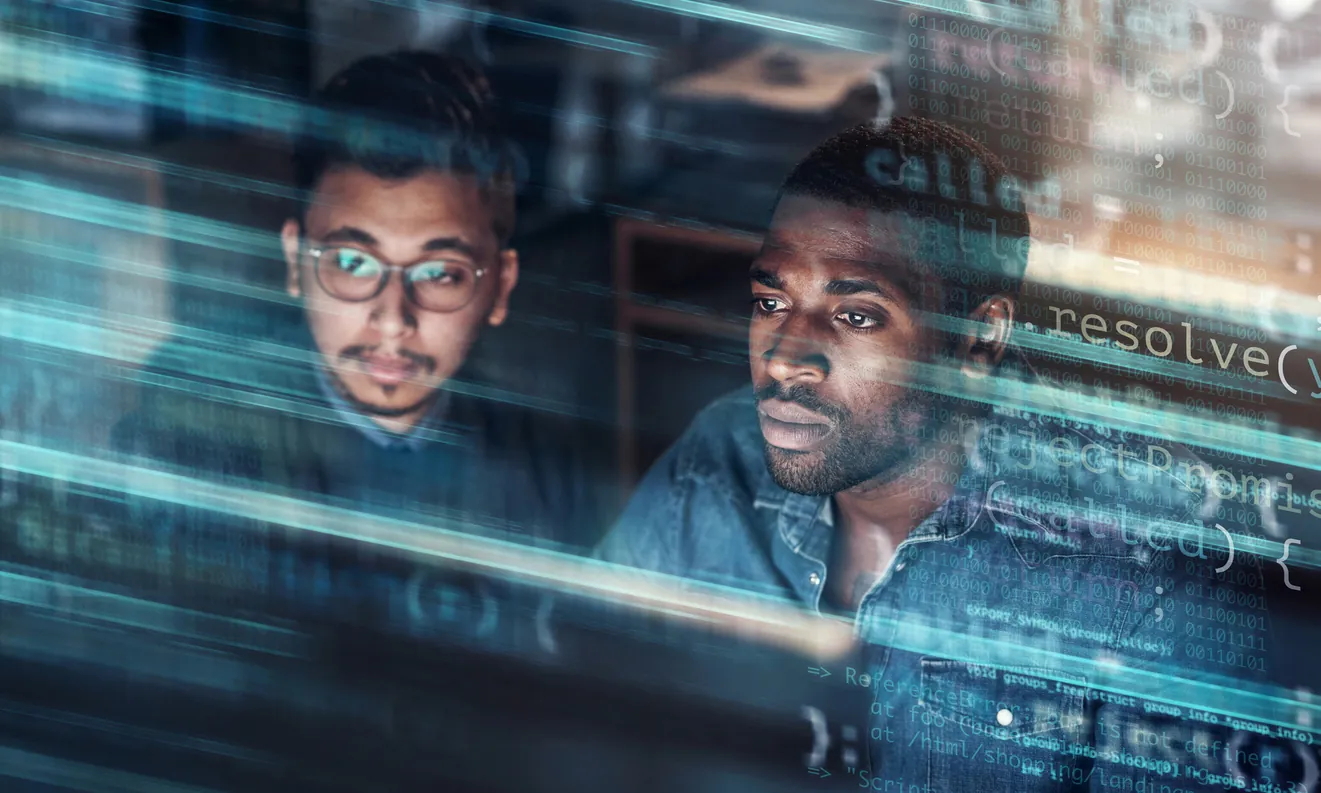 Two men focused on coding or programming, working in a tech environment. The background features blurred lines of code, suggesting a digital interface.