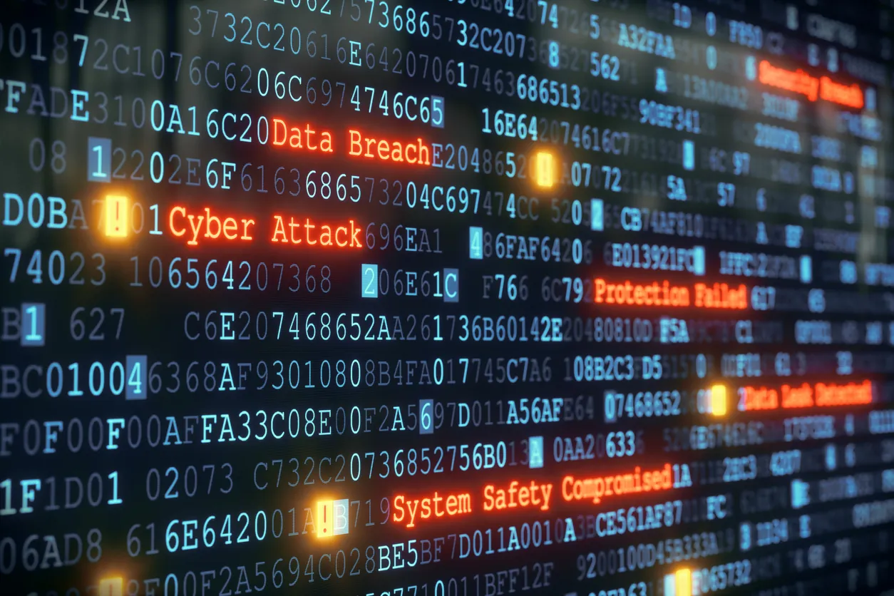 A digital display featuring code and text indicating security issues, including "Data Breach," "Cyber Attack," and "System Safety Compromised," against a dark background with glowing highlights.